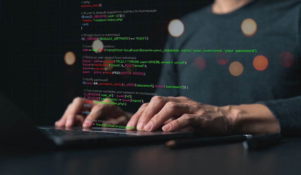 Developer typing on keyboard with website code overlay on dark background